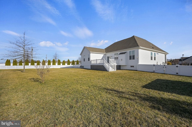 rear view of house with a yard and a deck