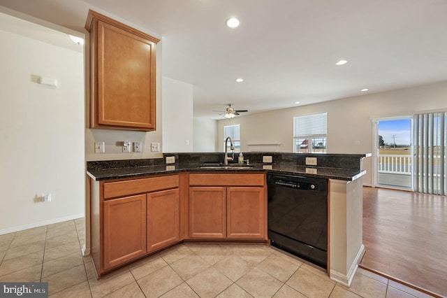 kitchen with dishwasher, sink, dark stone countertops, and kitchen peninsula