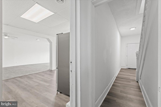 corridor with hardwood / wood-style flooring and a drop ceiling