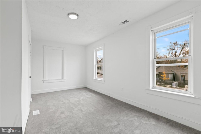 carpeted spare room with a textured ceiling