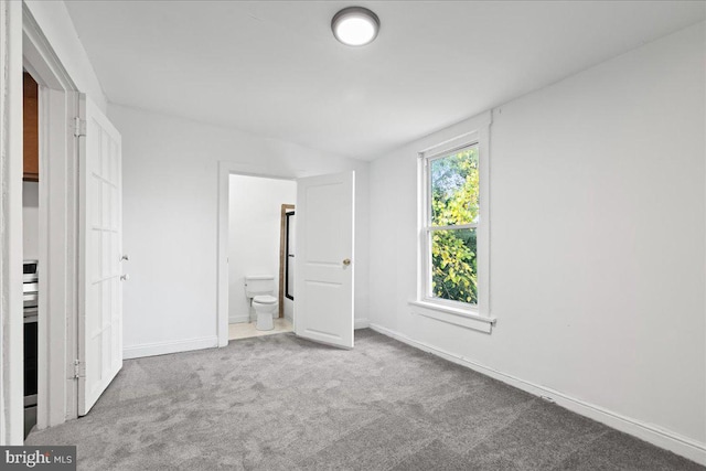 unfurnished bedroom featuring carpet flooring and ensuite bathroom