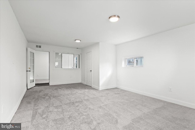 empty room featuring light carpet and french doors