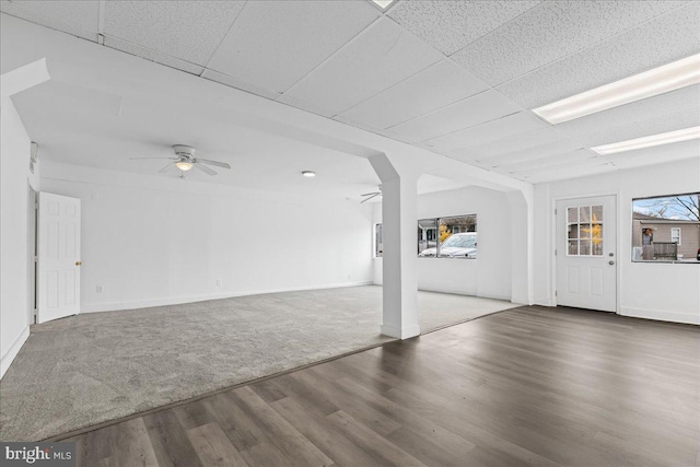 interior space featuring hardwood / wood-style flooring, ceiling fan, and a drop ceiling