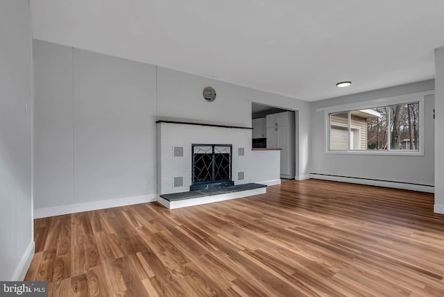 unfurnished living room with wood-type flooring and baseboard heating