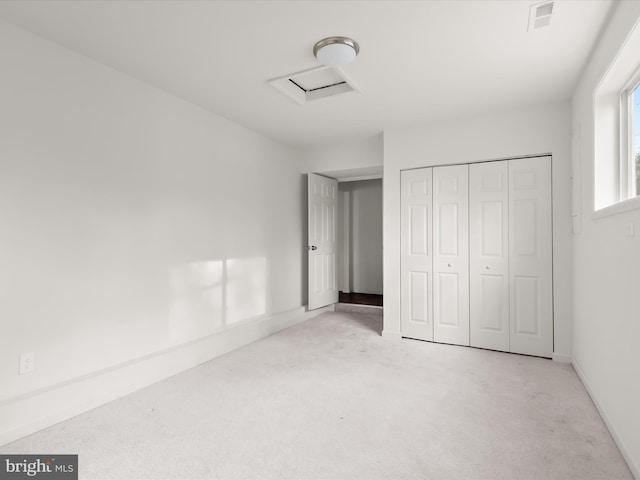 unfurnished bedroom featuring light carpet and a closet