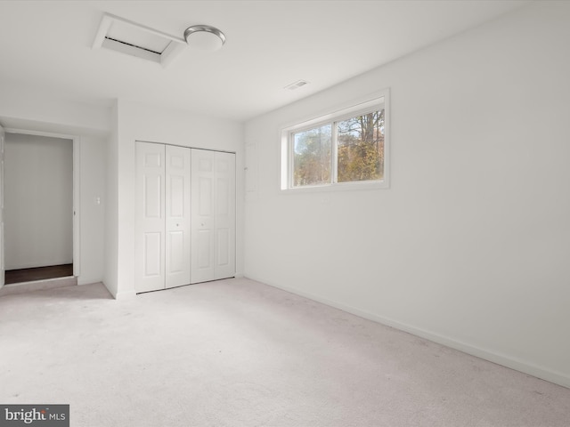 unfurnished bedroom featuring a closet and light colored carpet