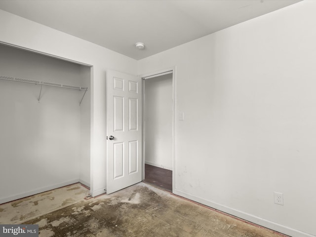 unfurnished bedroom featuring a closet and concrete flooring