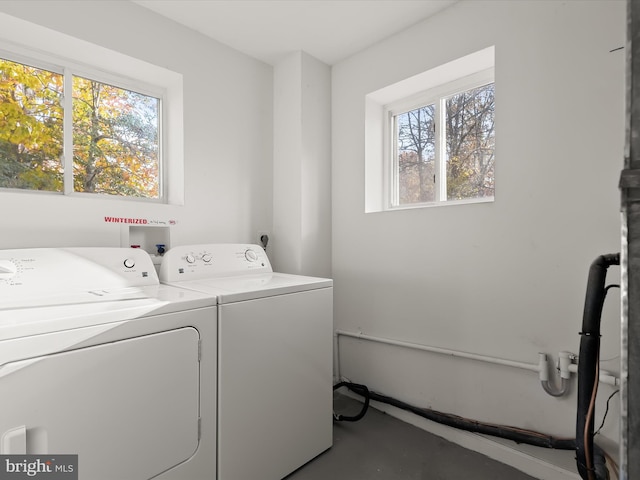 clothes washing area featuring washing machine and dryer and plenty of natural light