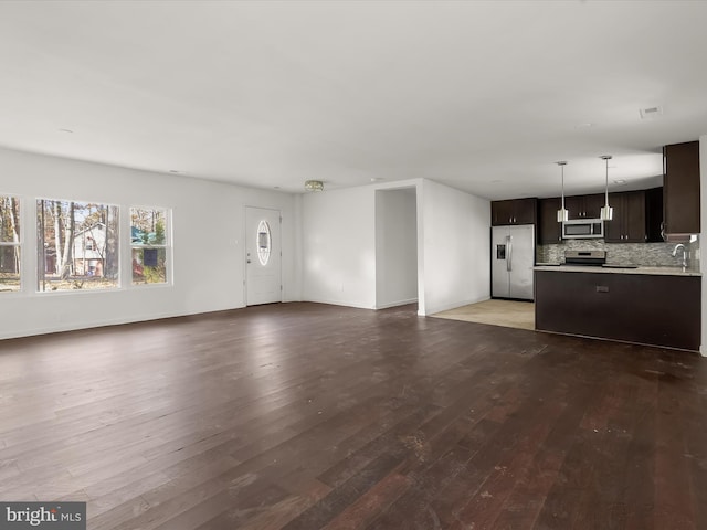 unfurnished living room featuring hardwood / wood-style floors and sink