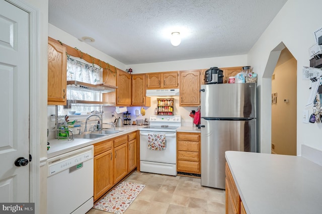 kitchen featuring white appliances, sink, and a textured ceiling