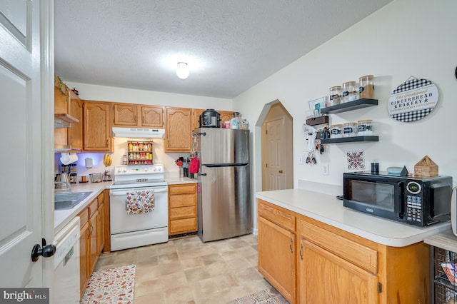 kitchen with sink, white appliances, and a textured ceiling