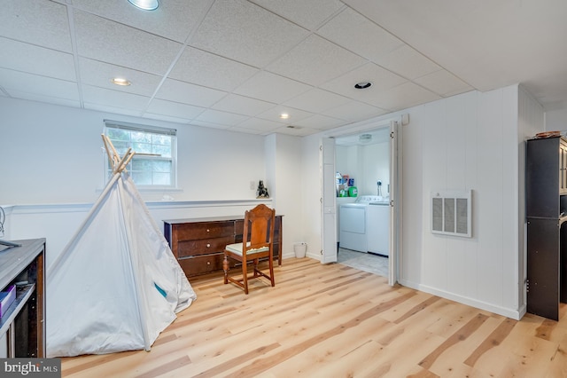 interior space featuring washer and clothes dryer, a paneled ceiling, and light wood-type flooring