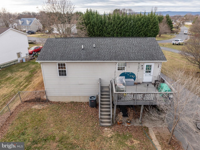 rear view of property with central AC unit, a yard, and a deck