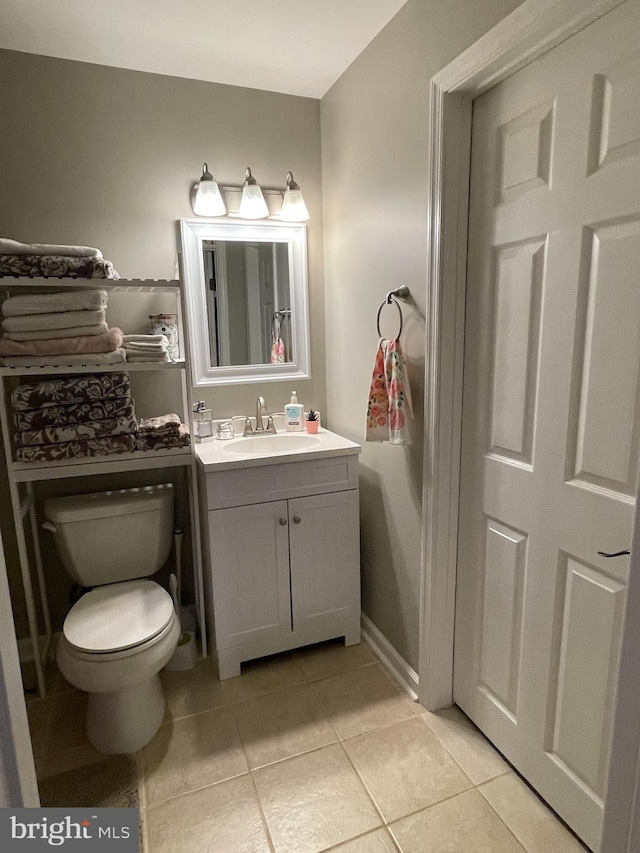 bathroom featuring tile patterned flooring, vanity, and toilet