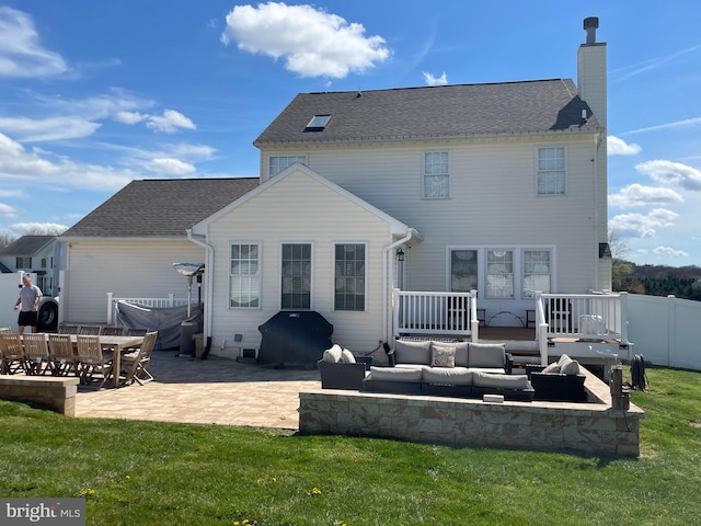 rear view of house featuring a yard, an outdoor living space, and a patio area