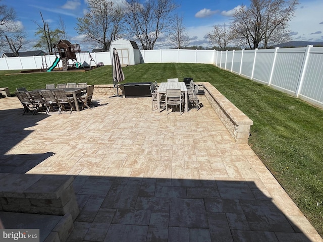 view of patio with a storage shed and a playground