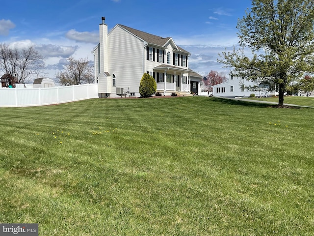 rear view of house featuring covered porch, a yard, and central air condition unit