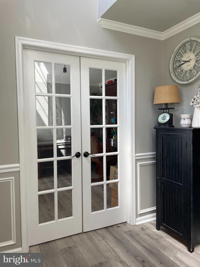 doorway with crown molding, french doors, and light hardwood / wood-style flooring