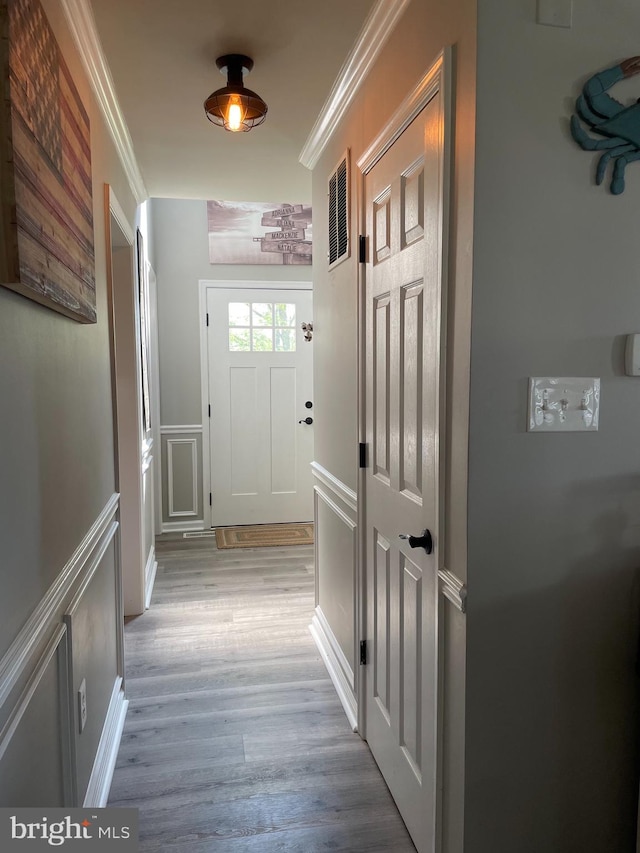 corridor featuring crown molding and light hardwood / wood-style floors