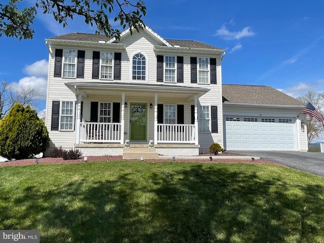 colonial inspired home featuring a front yard, a porch, and a garage