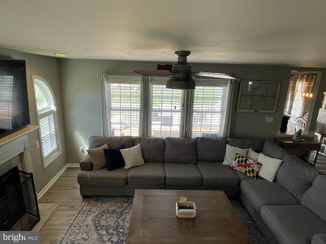 living room with wood-type flooring, a wealth of natural light, and ceiling fan