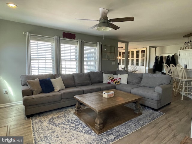 living room featuring hardwood / wood-style floors and ceiling fan