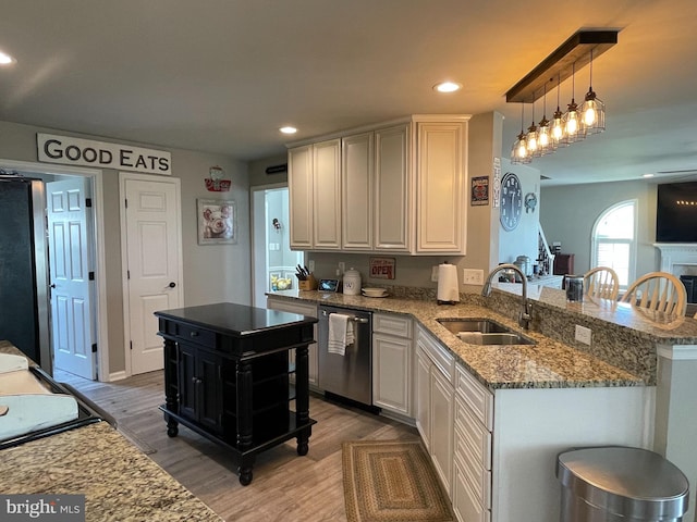 kitchen with sink, a kitchen island, hardwood / wood-style floors, and appliances with stainless steel finishes