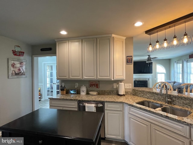 kitchen featuring pendant lighting, white cabinets, sink, ceiling fan, and light stone countertops