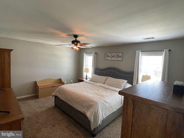 carpeted bedroom featuring multiple windows and ceiling fan