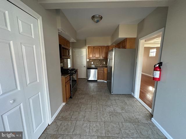 kitchen featuring light hardwood / wood-style flooring, appliances with stainless steel finishes, and tasteful backsplash