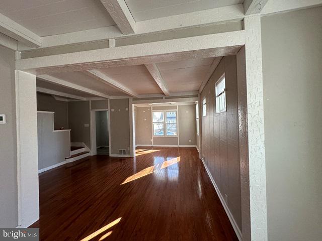 interior space featuring beamed ceiling and dark hardwood / wood-style floors