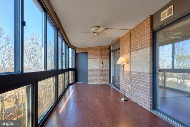 8370 Greensboro Dr Unit 414, Mclean, VA 22102 - unfurnished sunroom featuring brick wall, ceiling fan, wood finished floors, and plenty of natural light