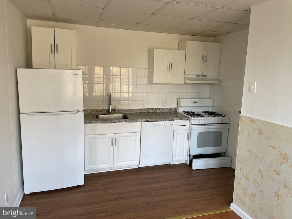 kitchen with white cabinets, white appliances, dark hardwood / wood-style floors, and sink