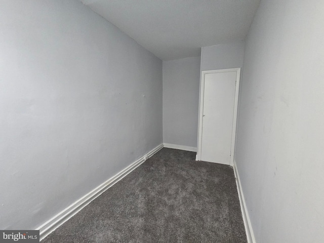 unfurnished room with dark colored carpet