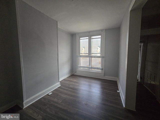 unfurnished room featuring dark wood-type flooring