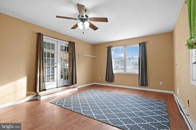 spare room featuring hardwood / wood-style floors, ceiling fan, and baseboard heating