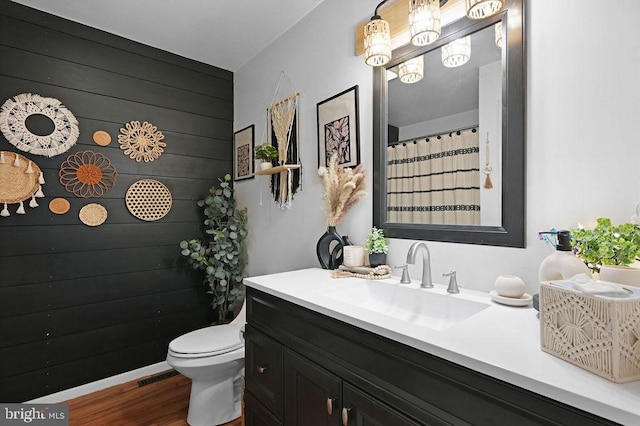 bathroom featuring wood-type flooring, vanity, and toilet