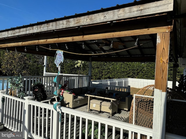 wooden deck featuring a gazebo, ceiling fan, and an outdoor hangout area