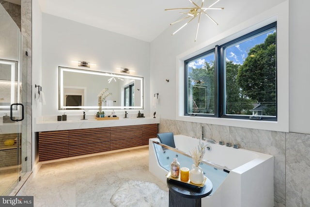 bathroom with vanity, independent shower and bath, and a notable chandelier