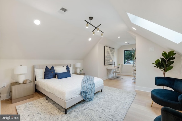 bedroom with light wood-type flooring and lofted ceiling with skylight