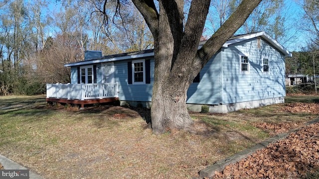 view of front of property with a wooden deck and a front lawn