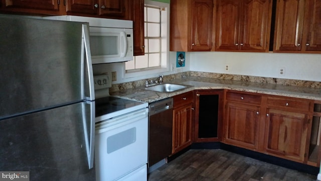 kitchen featuring light stone countertops, dark hardwood / wood-style flooring, stainless steel appliances, and sink