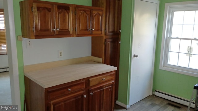 7105 Wainwright Ave, Parsonsburg, MD 21849 - kitchen featuring a baseboard radiator, light countertops, brown cabinets, and light wood-style flooring
