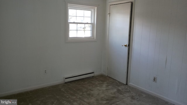 carpeted spare room featuring baseboard heating