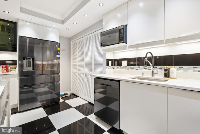 kitchen featuring refrigerator with ice dispenser, white cabinetry, crown molding, and sink