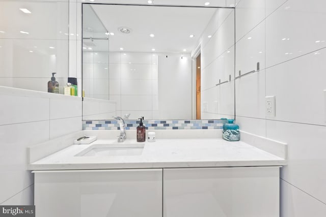 bathroom with vanity and tile walls