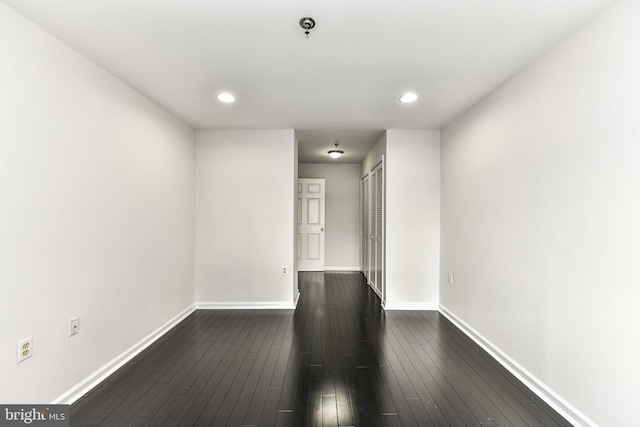 unfurnished room with dark wood-type flooring