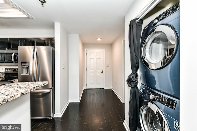 interior space with dark hardwood / wood-style floors and stacked washer and clothes dryer