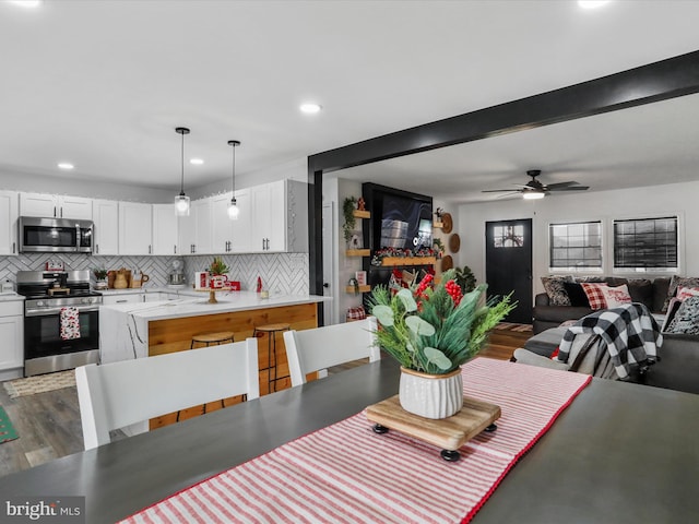 dining area featuring ceiling fan, beamed ceiling, and dark hardwood / wood-style floors