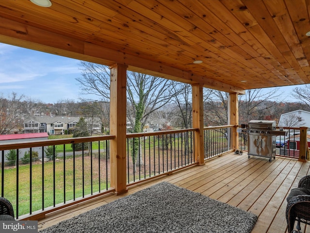 wooden deck with area for grilling and a yard